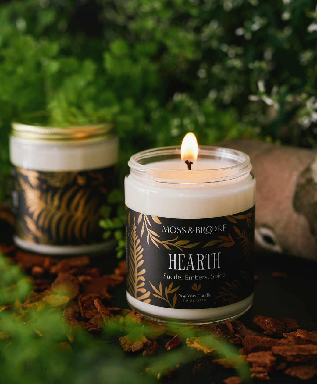 Moss and Brooke brand identity shown on custom candle packaging labels with gold foil